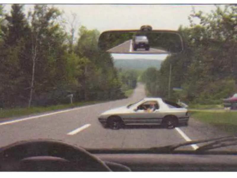 Autoturismul alb execută manevra de întoarcere. Cum vei proceda corect?